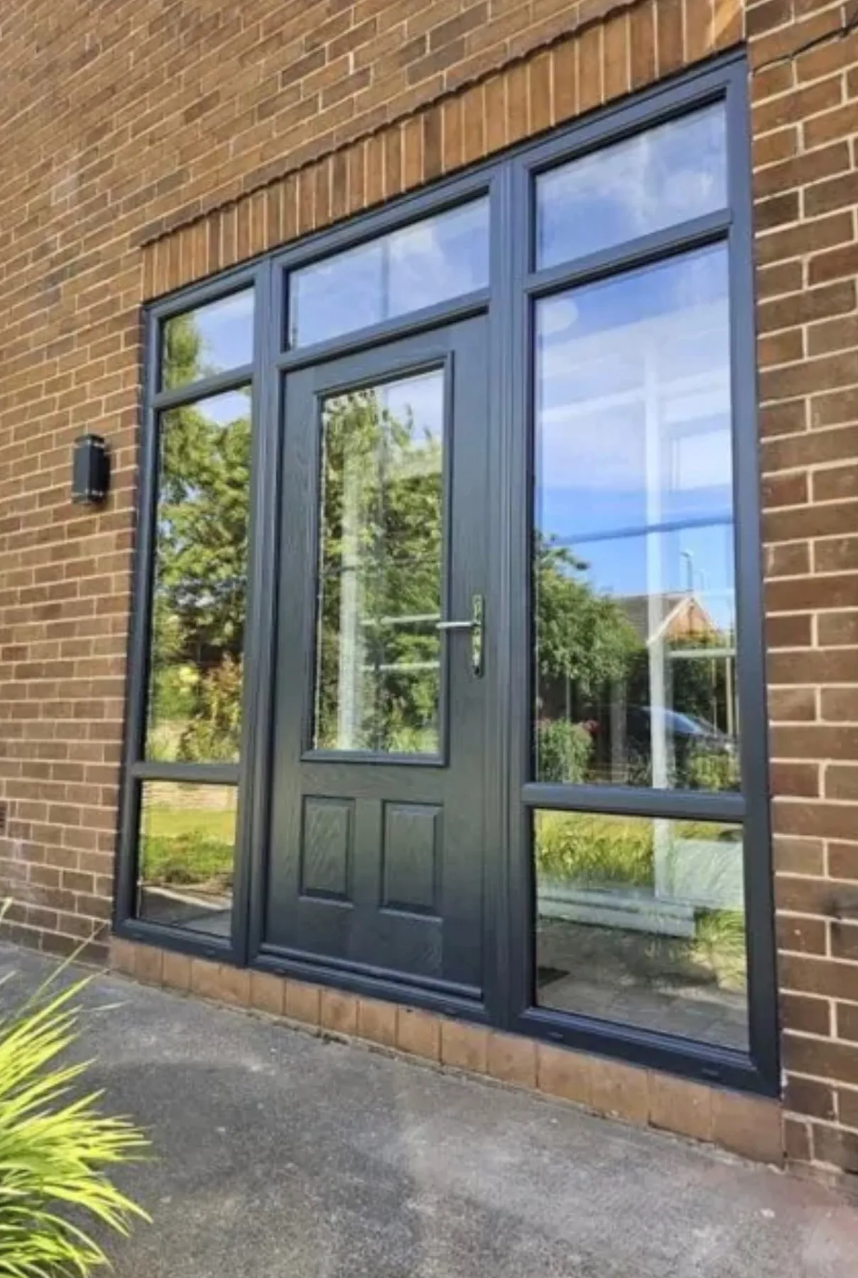 Grey French doors fitted to a brick home