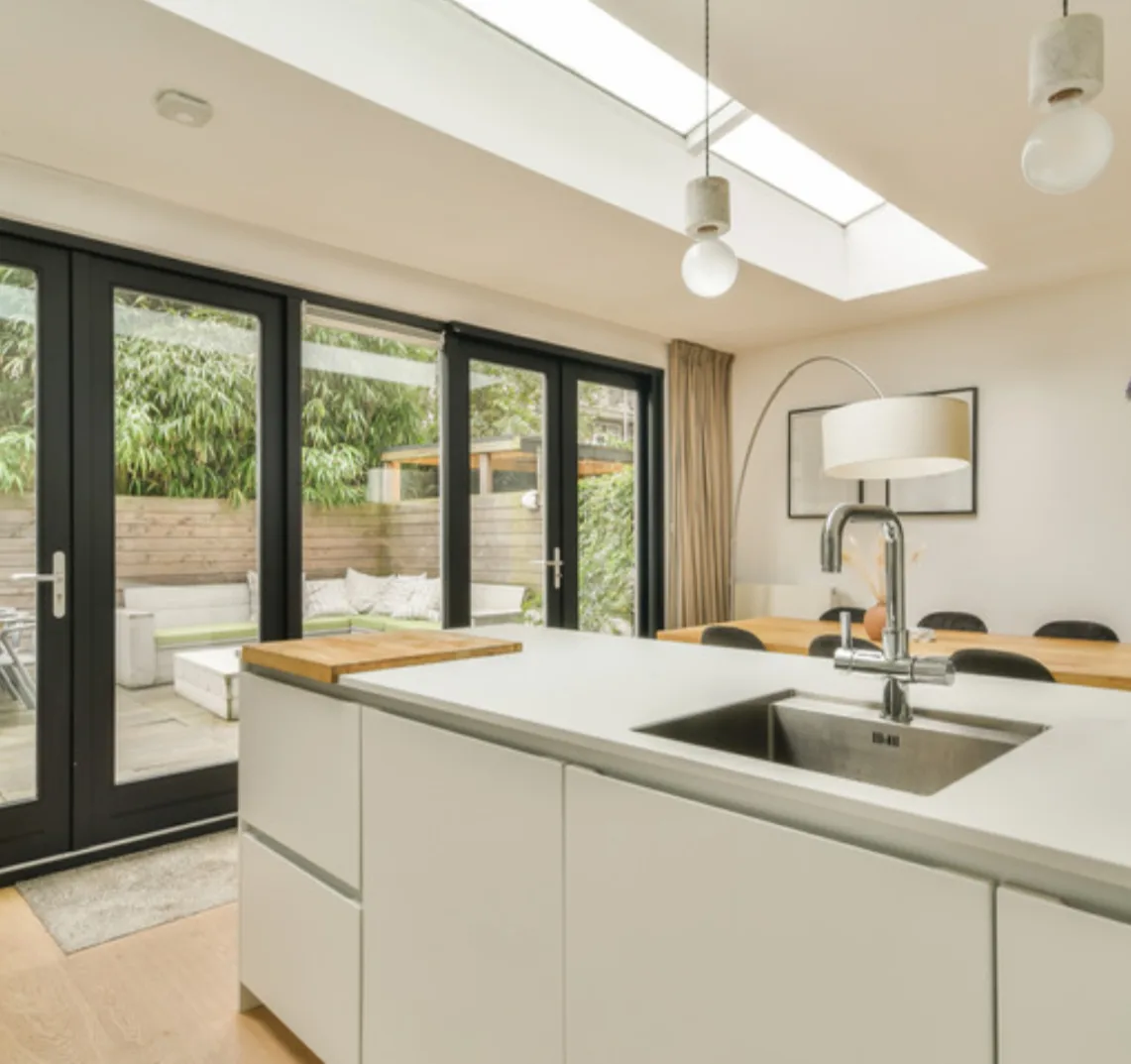 Black aluminium patio doors opening a kitchen to the garden