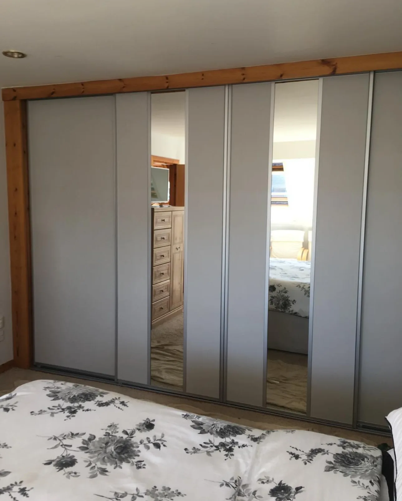 Made-to-measure grey sliding wardrobe doors with mirrored panel